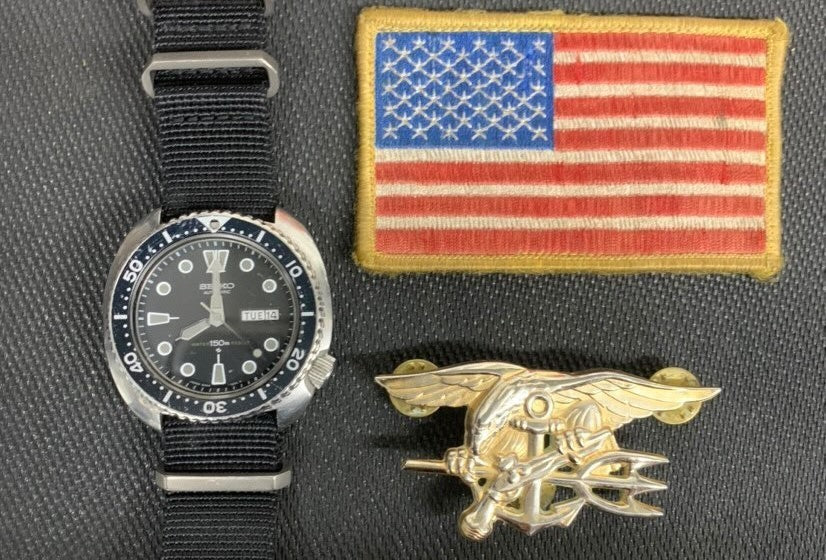 Kyle Defoor’s Seiko on a Prometheus Design Works strap along with his SEAL Trident, Red Squadron and American Flag patches he wore in Afghanistan.
